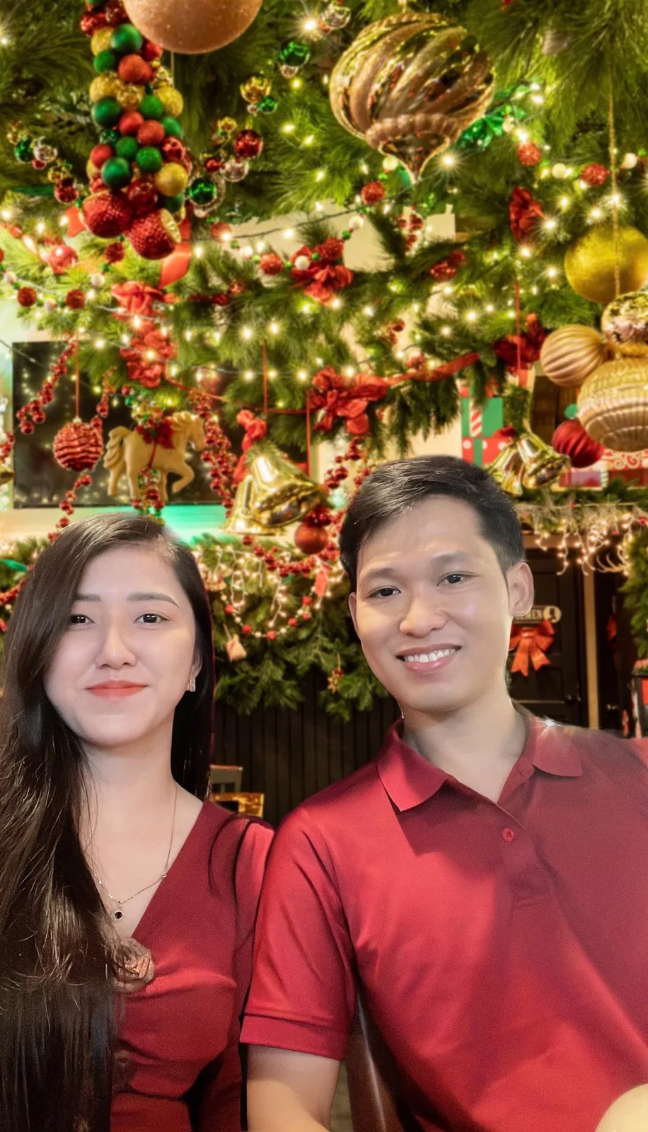 Hai bạn trong trang phục đỏ, bên ánh đèn ấm áp